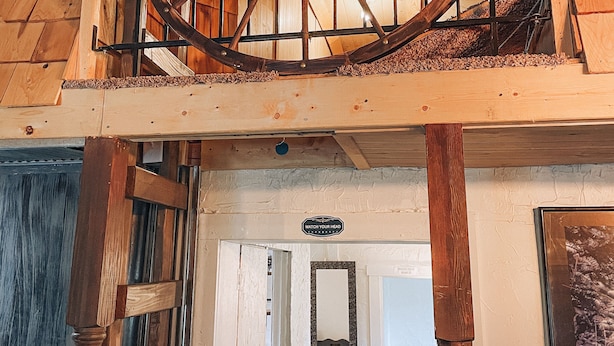 A wooden spiral staircase with a metal railing, leading to an upper level. - Wolf's Cabin Near Historic Downtown Noblesville (Noblesville)