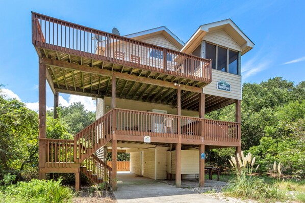 Eine zweistöckige Holzhütte mit Balkon und überdachter Veranda.