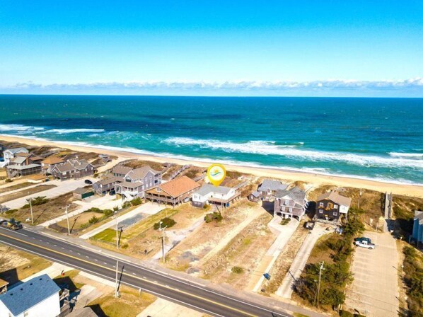 Stilted homes line the beachfront, offering access to the ocean.