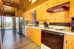 Enjoy cooking in this well-equipped kitchen with a central island, stainless steel appliances, and a window offering a view of the outdoors.