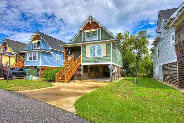 A row of single-family homes with a front porch, a driveway, and a street view.