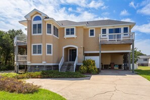 A two-story house with a balcony, a front porch, and a driveway.