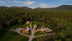 Vue aérienne d’une propriété rurale comprenant plusieurs maisons, une grange et une allée.
