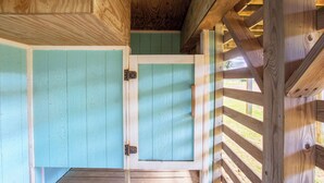 Una estructura de madera con una puerta y una ventana.