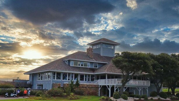 A large, two-story house with a prominent tower, a covered porch, and a well-maintained lawn. - 6140 Spindrift * On the Golf Course (Nags Head)
