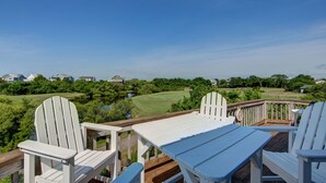 A deck with Adirondack chairs and a table overlooking a golf course. - 6140 Spindrift * On the Golf Course (Nags Head)