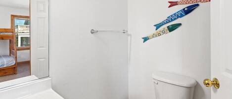 A bathroom with a toilet, a sink, and a shower door.