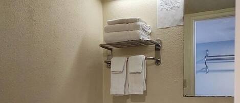 A standard hotel bathroom with a toilet, sink, and towel rack.