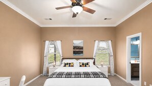 A bedroom with a bed, a desk, a chair, a ceiling fan, and two windows with curtains. - Perfect Stay in Ranch-like House with Huge Backyard! (Forney)