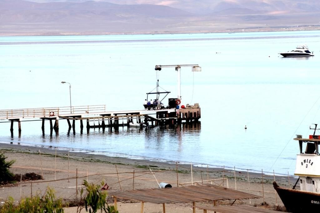 Un muelle que se adentra en aguas tranquilas con una embarcación amarrada al final.