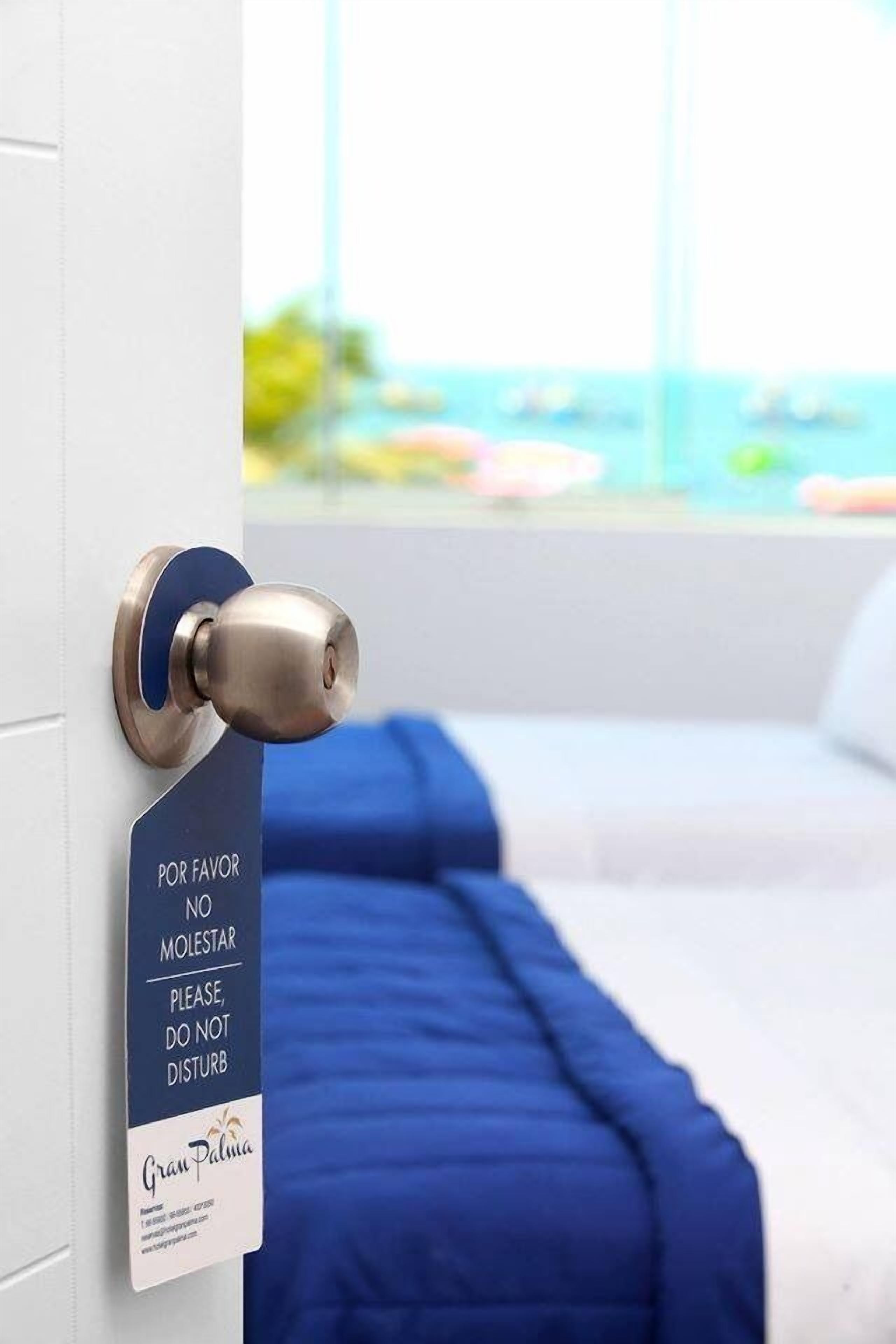 Une porte avec une pancarte indiquant « POR FAVOR NO MOLESTAR PLEASE DO NOT DISTURB » et le nom « Gran Palma ».
