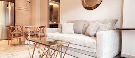 A modern living room with a sofa, coffee table, and wooden chairs.