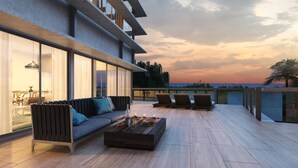 A modern outdoor living area with a sofa, chairs, and a coffee table. - Singular Dream Beach Residences (Playa del Carmen)
