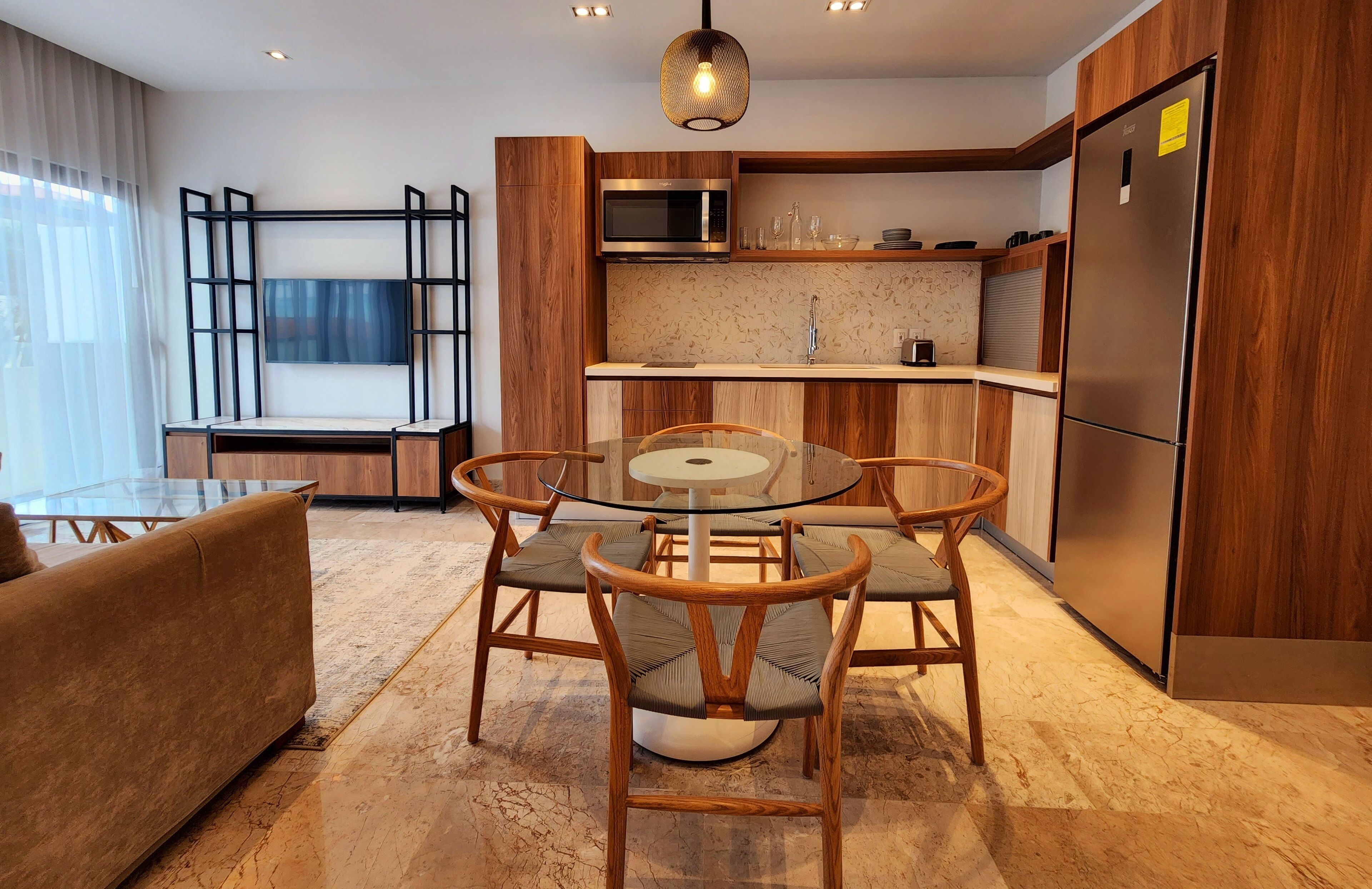 A modern kitchen with wooden cabinets, a built-in microwave, and a stainless steel refrigerator.