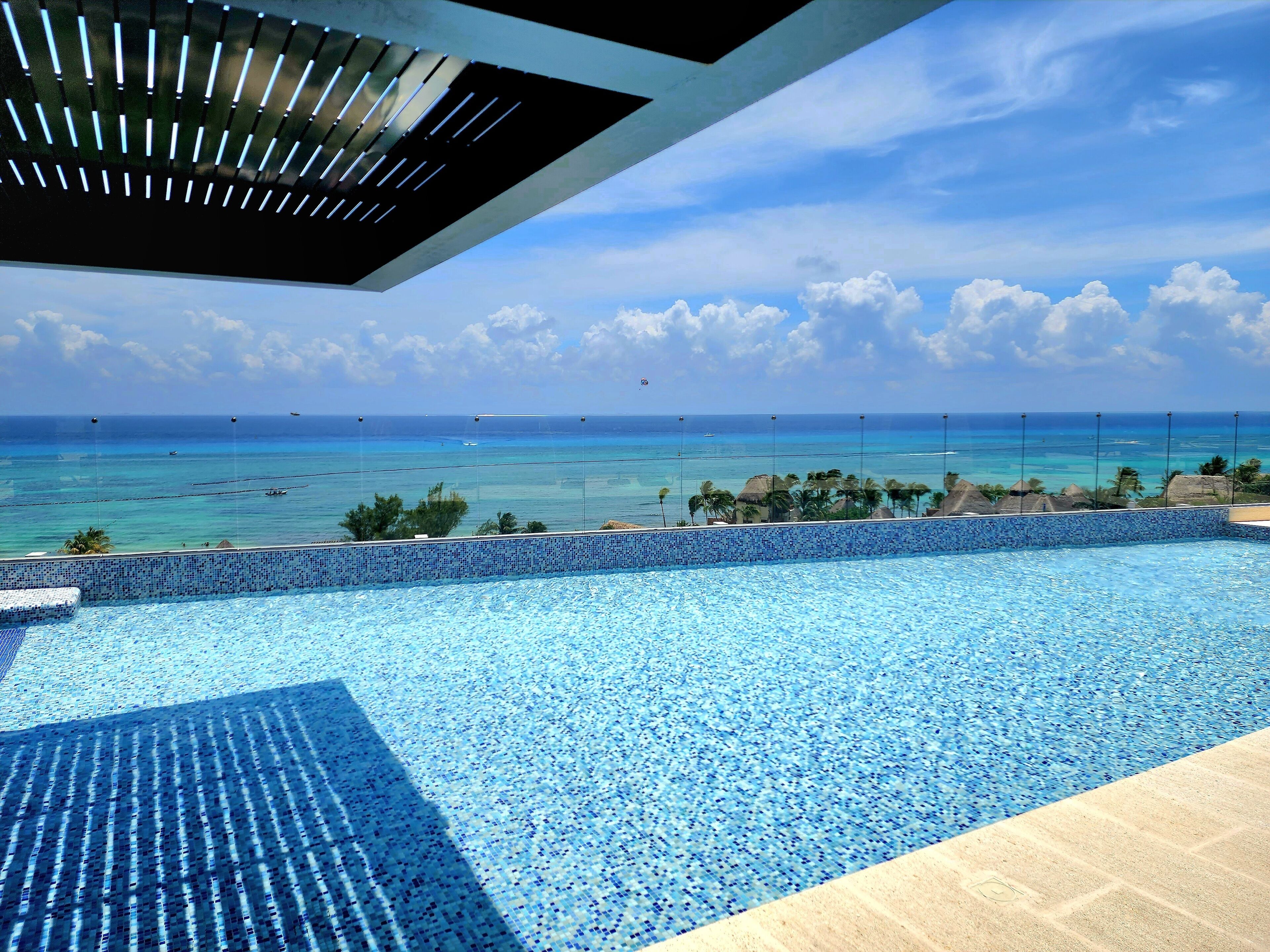 A pool with a clear view of the ocean and sky.
