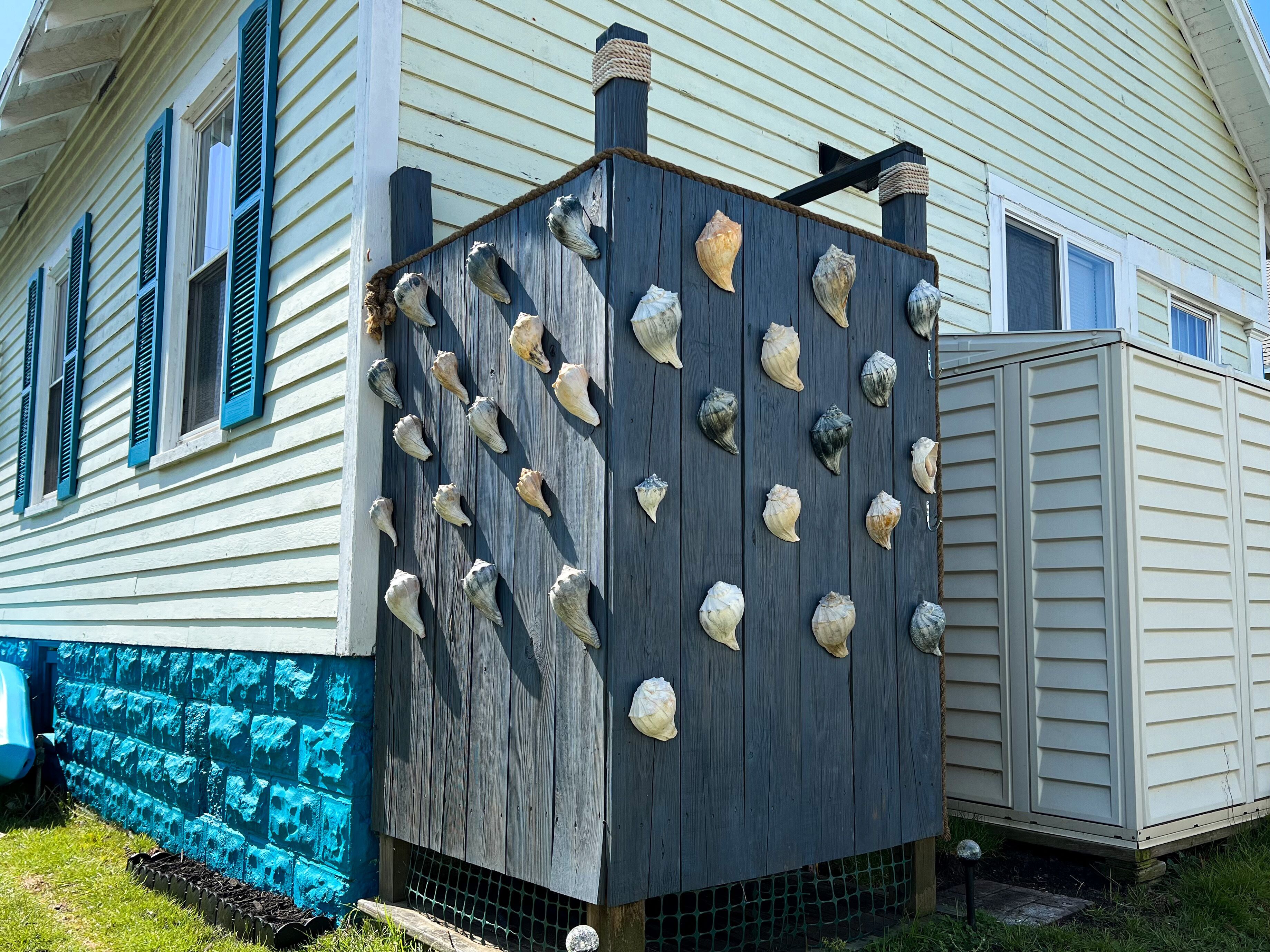 A house with a wooden exterior, a blue door, and a window with shutters.