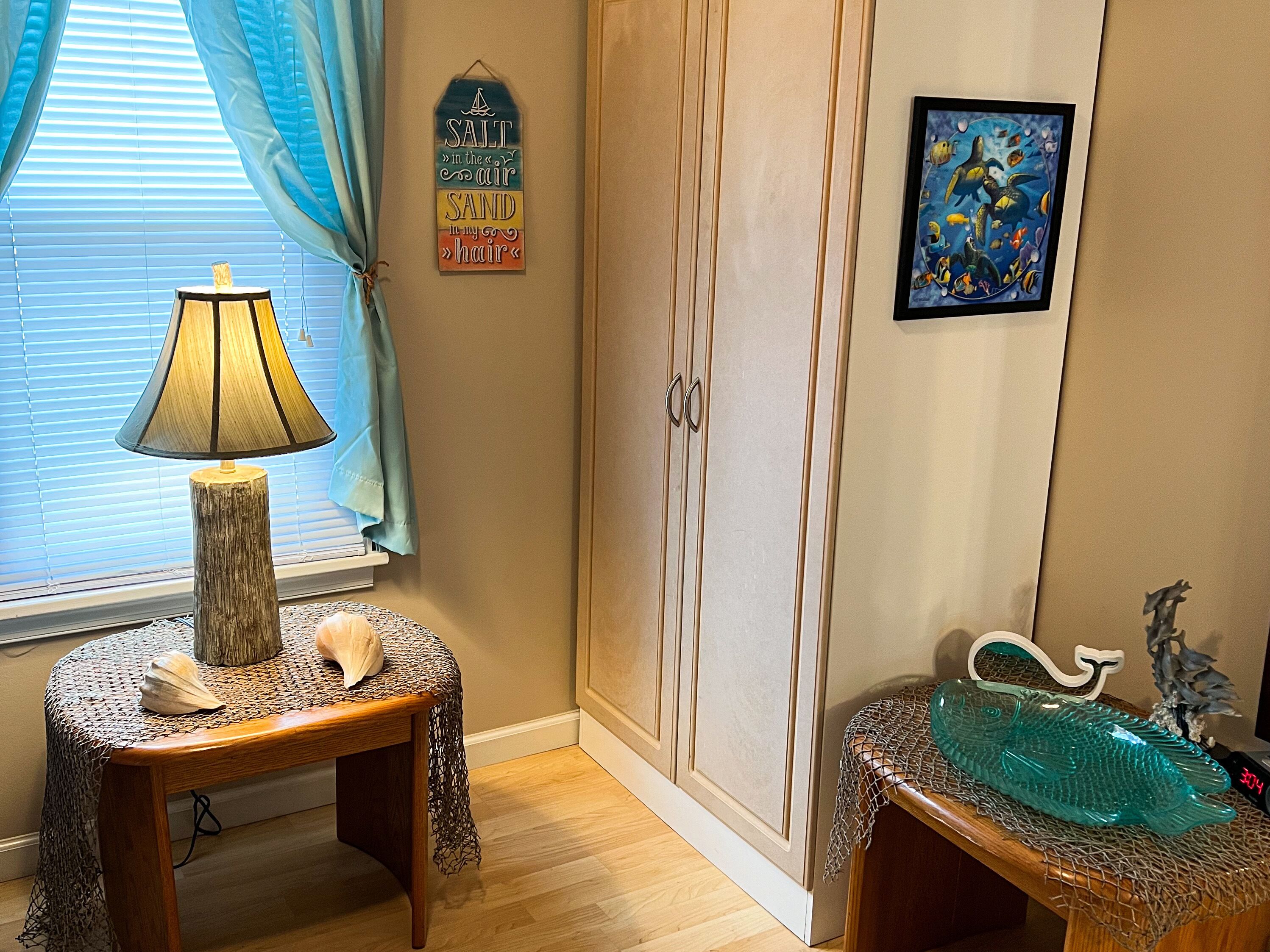 Une pièce comprenant une table en bois, une lampe, un aquarium décoratif, un meuble et une œuvre d’art murale.