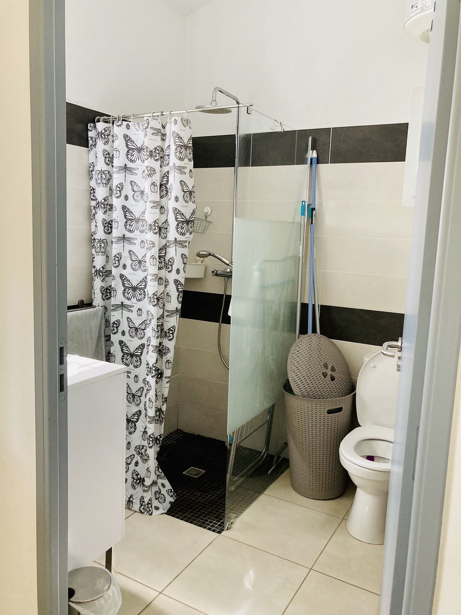 A bathroom with a shower, toilet, and sink.