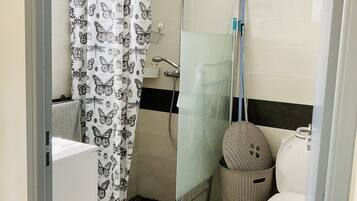 A bathroom with a shower, toilet, and sink.
