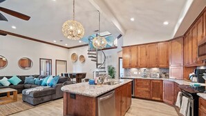 A modern kitchen with wooden cabinets, granite countertops, and stainless steel appliances. - Secluded Getaway with Pool and Game Room (Galveston)