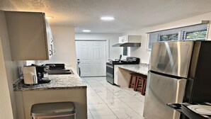 A modern kitchen with stainless steel appliances, a marble countertop, and a trash bin. - 5 springs 4 to 10 minutes away Goats, Chickens, Free Eggs, Memories FARM Setting (Apopka)