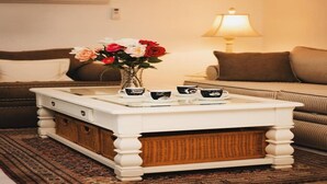 A white coffee table with a vase of flowers and three teacups on a patterned rug. - 5 springs 4 to 10 minutes away Goats, Chickens, Free Eggs, Memories FARM Setting (Apopka)