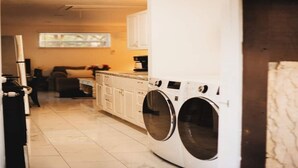 A laundry room with a front-loading washer and dryer, white cabinets, and a tiled floor. - 5 springs 4 to 10 minutes away Goats, Chickens, Free Eggs, Memories FARM Setting (Apopka)