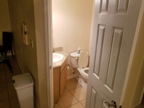 A compact bathroom with a toilet, sink, and trash bin. - Clean Pool Walk to Beach - Pet Ok - Ground Floor (South Padre Island)