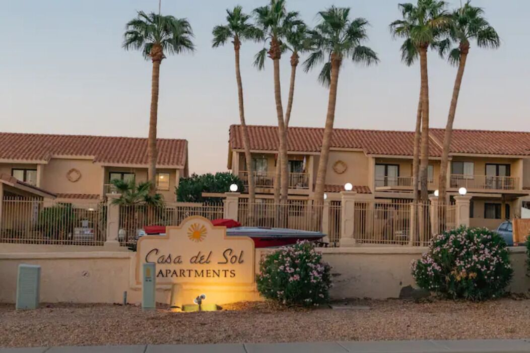 A multi-story apartment building with a sign reading "Casa del Sol Apartments."