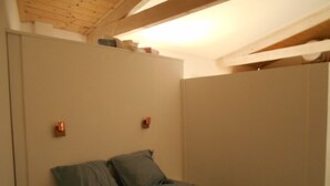 Een slaapkamer met een bed, twee nachtkastjes en een kledingkast.