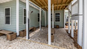 Un espace extérieur abrité, doté de bancs en bois et d’un sol en briques.