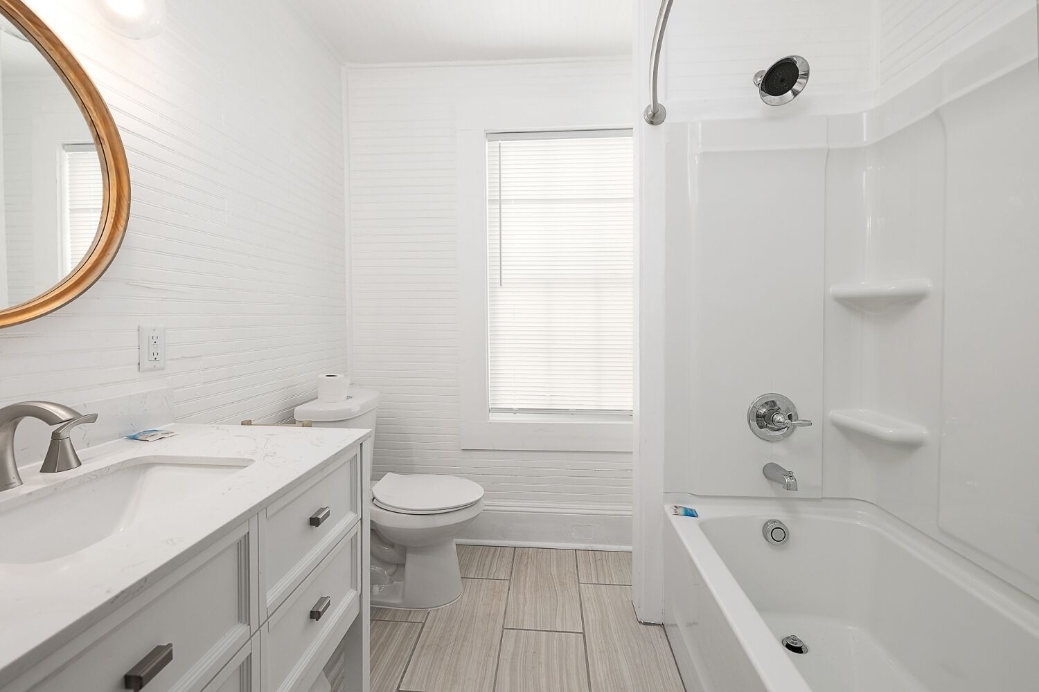 Une salle de bain moderne avec un meuble-lavabo blanc, des toilettes et une baignoire.