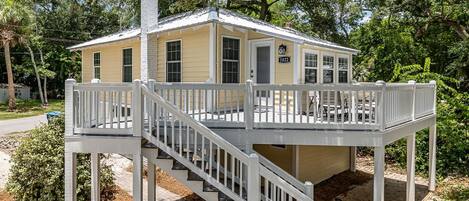 A two-story house with a covered porch and a staircase.