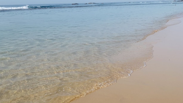 Ein Strand mit klarem Wasser und sandigem Ufer.