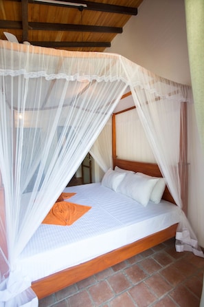 A bed with a wooden frame and white bedding, covered by a white canopy. - Lovely Two Bedroom Apartment near Unawatuna beach. (Unawatuna)