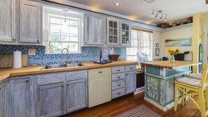A kitchen with a wooden countertop, a sink, and a window.