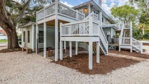 A two-story house with a covered porch and a staircase.