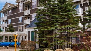 A residential building with balconies, a swimming pool, and surrounding greenery.