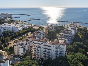 Un quartier résidentiel situé sur la côte, avec des immeubles à plusieurs étages, une plage et une jetée.