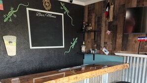 A bar area with a wooden counter, black stools, and a blackboard menu sign. - Beautiful Waterfront  Home on a Private Lake!   (Quinlan)
