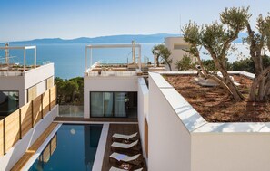 A modern villa with a pool, outdoor seating, and a view of the sea. - Cozy home in Omis with sauna (Omis)