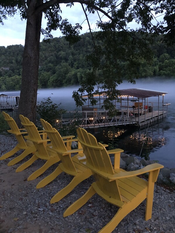 Outdoor seating with Adirondack chairs, a dock, and a lake view.
