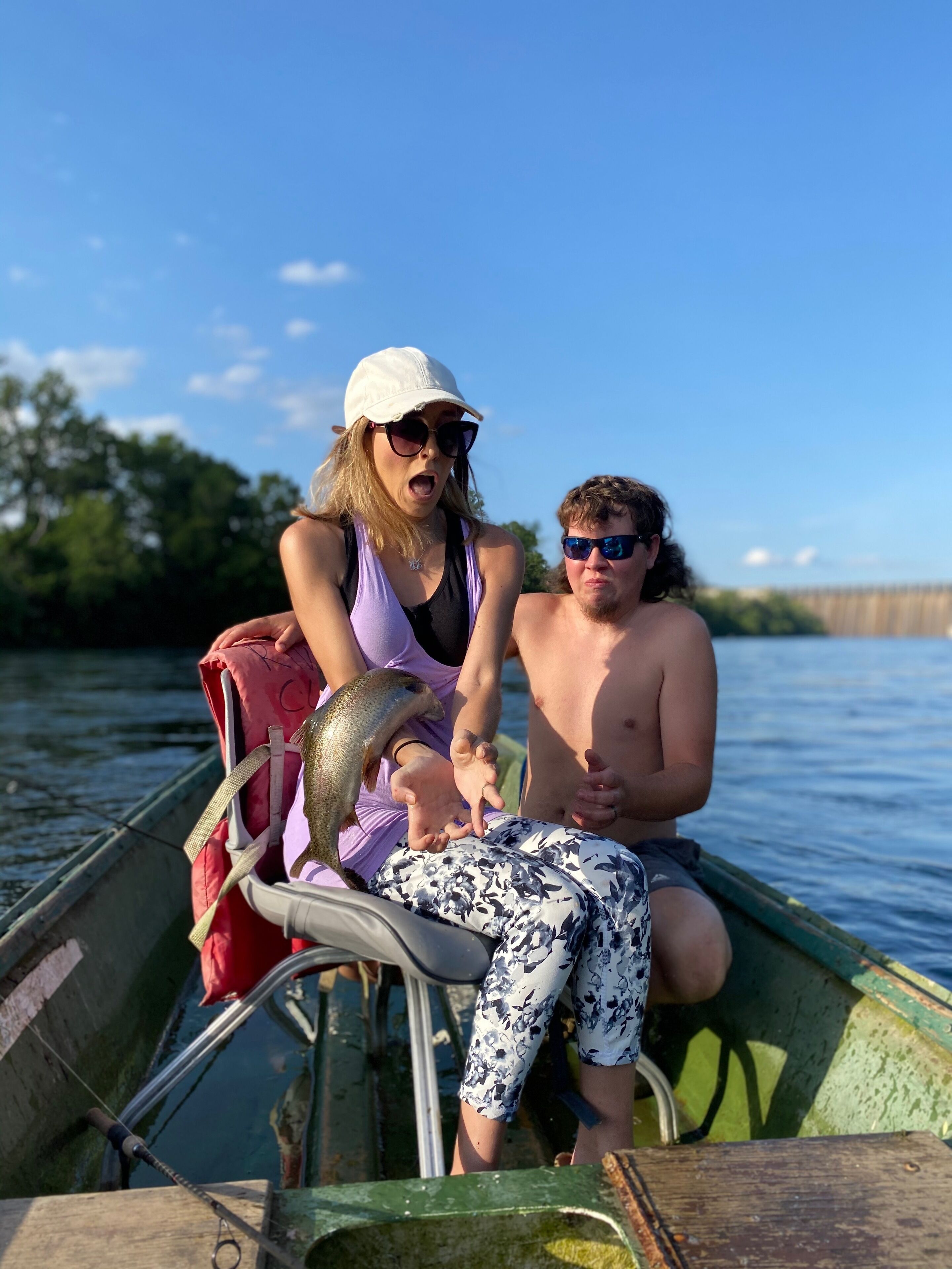 Two people in a small boat on a body of water.