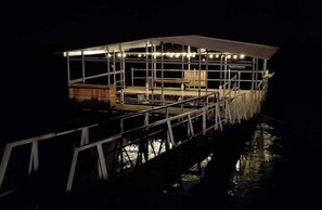 A boat with a covered deck and railings, surrounded by water.