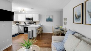 A compact living space with a kitchenette, dining area, and a sofa.