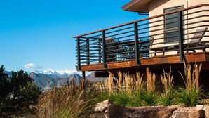 Un edificio moderno con balcón que ofrece vistas a un paisaje montañoso.