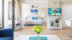 A modern hotel room with a bed, a TV, a desk, and a chair. - High-floor Waikiki retreat w/ beach essentials (Honolulu)