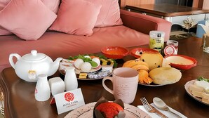 Une table à manger dressée avec différents plats, une théière et un panneau indiquant « Rose Park ».