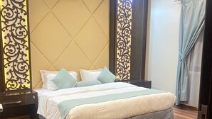 Une chambre moderne avec un grand lit, un parquet en bois foncé et des panneaux muraux décoratifs.