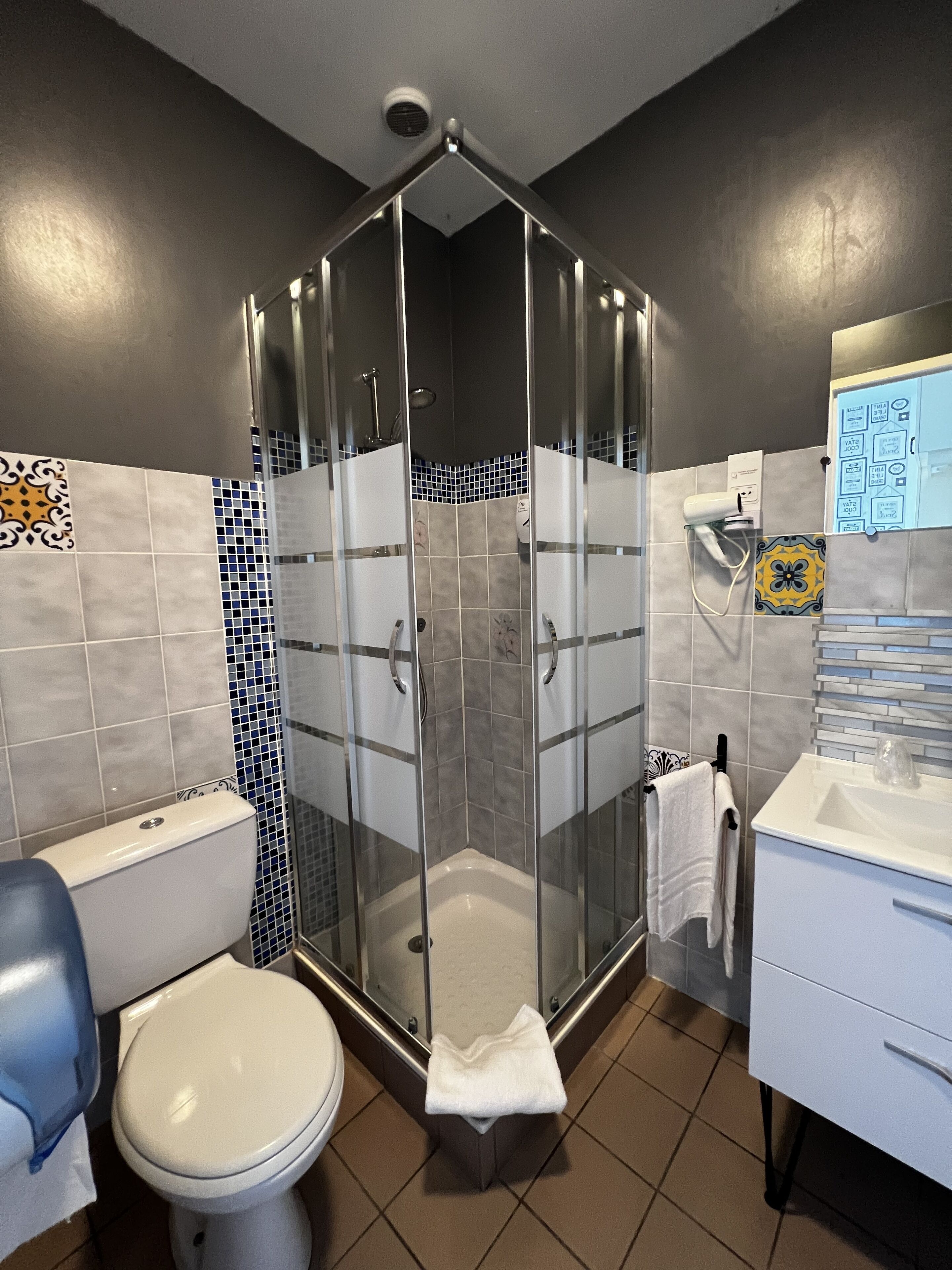 Un baño moderno con ducha de vidrio, inodoro y lavamanos.